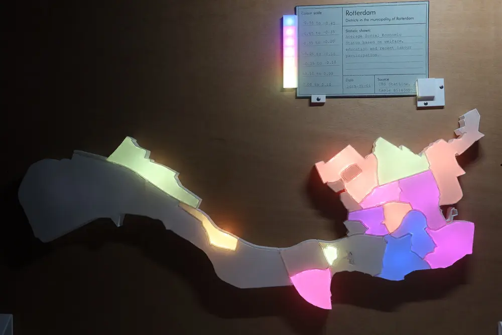 Picture of the visualisation with a card inserted. Some of the neighbourhoods are lighted up with different colours ranging from purple to light yellow. At the top the green card showing the description of the data and a legend going from -0.55 to 0.1.